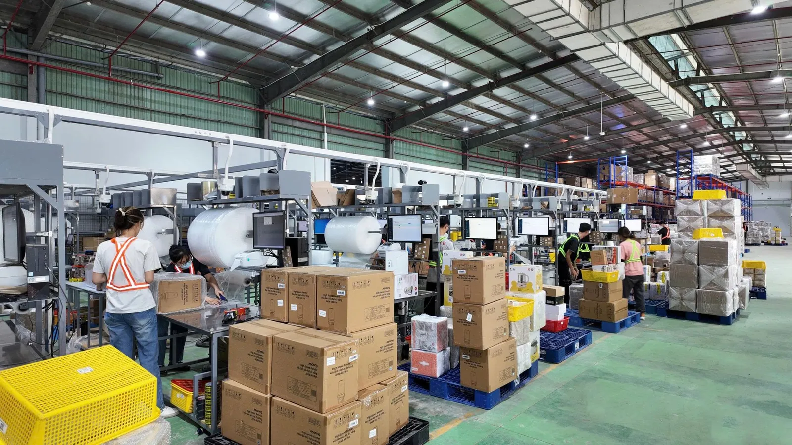Nhân viên xử lý và đóng gói đơn hàng tại dãy bàn trong kho Onflow