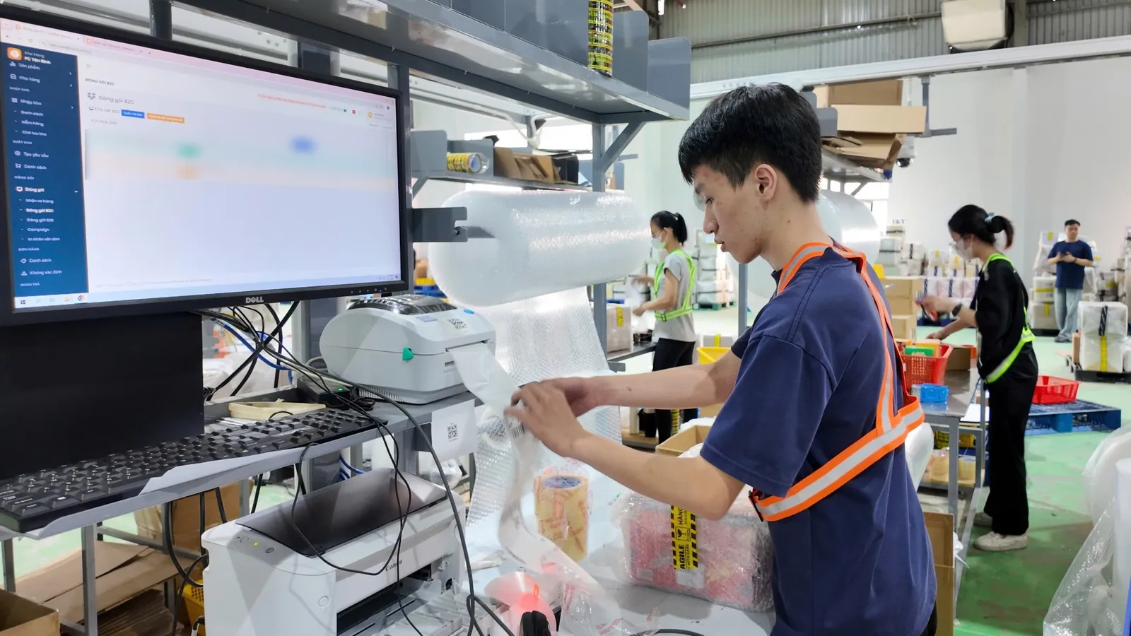 Nhân viên in nhãn vận đơn và đóng gói hàng trên hệ thống Onflow