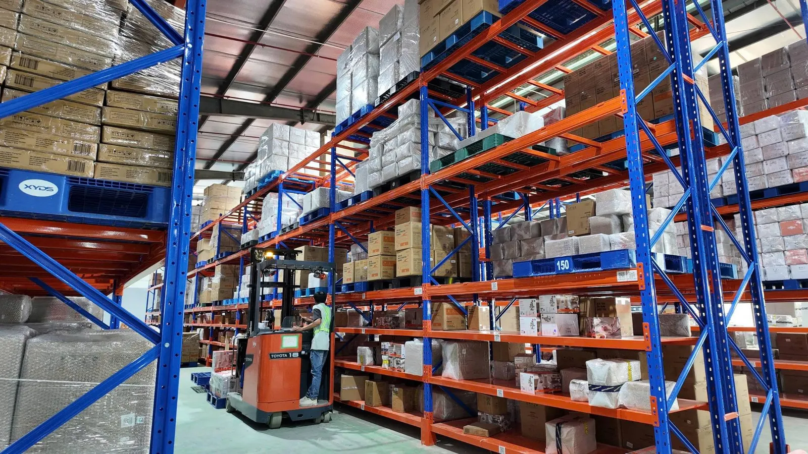 Hệ thống kệ pallet cao tầng và xe nâng điện trong kho Onflow