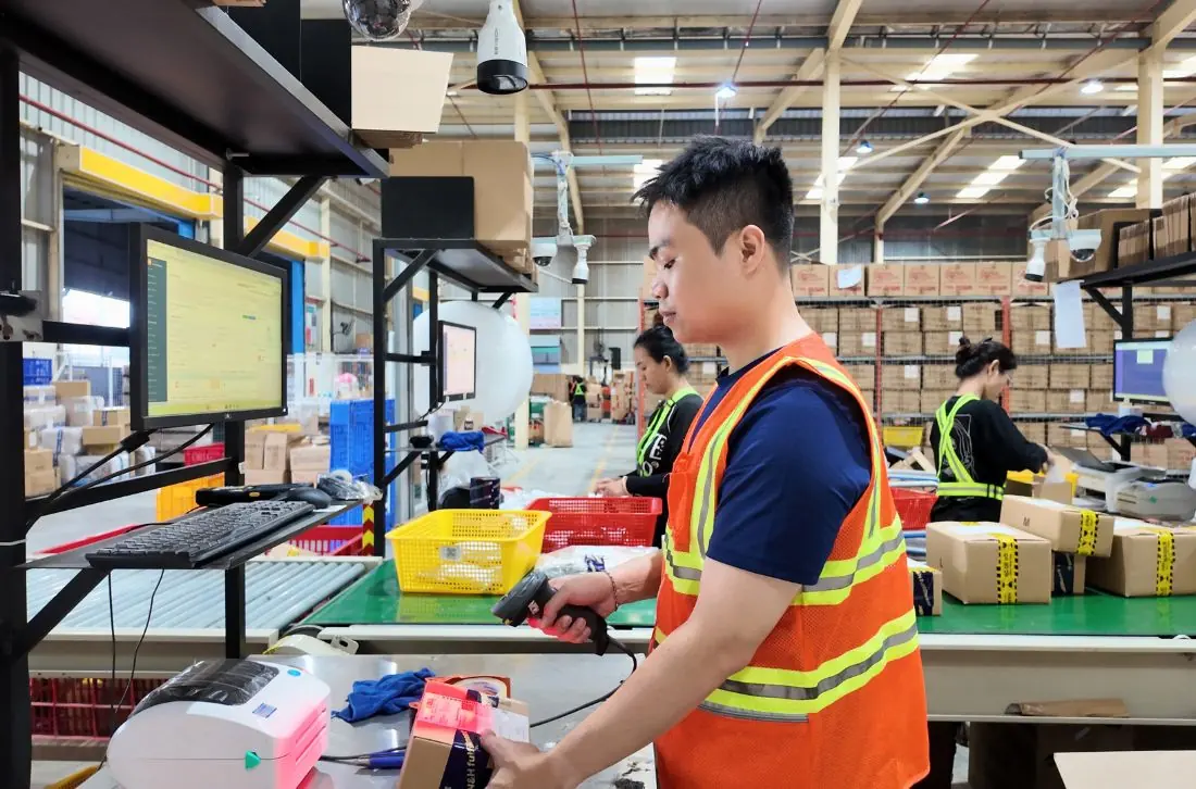 Nhân viên quét mã vạch kiểm tra đơn hàng tại bàn đóng gói kho Fulfillment
